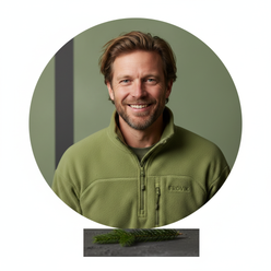 Circular portrait of Finn O'Shea, a man with a beard, smiling and wearing a fleece jacket against a subtly tinted green backg