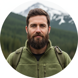 Portrait of Kasper Nielsen, a man with a beard, wearing a FROVIK Outdoor Fleece Jacket, against a soft forest green backgroun